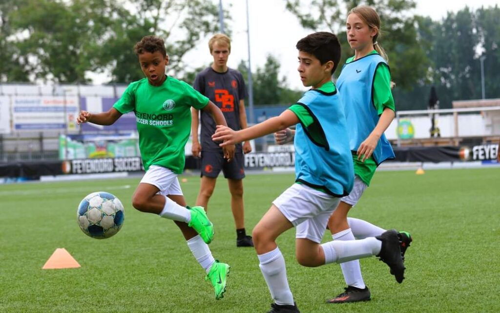Ik geef namens Feyenoord een voetbaltraining aan kinderen tijdens een voetbalkamp.